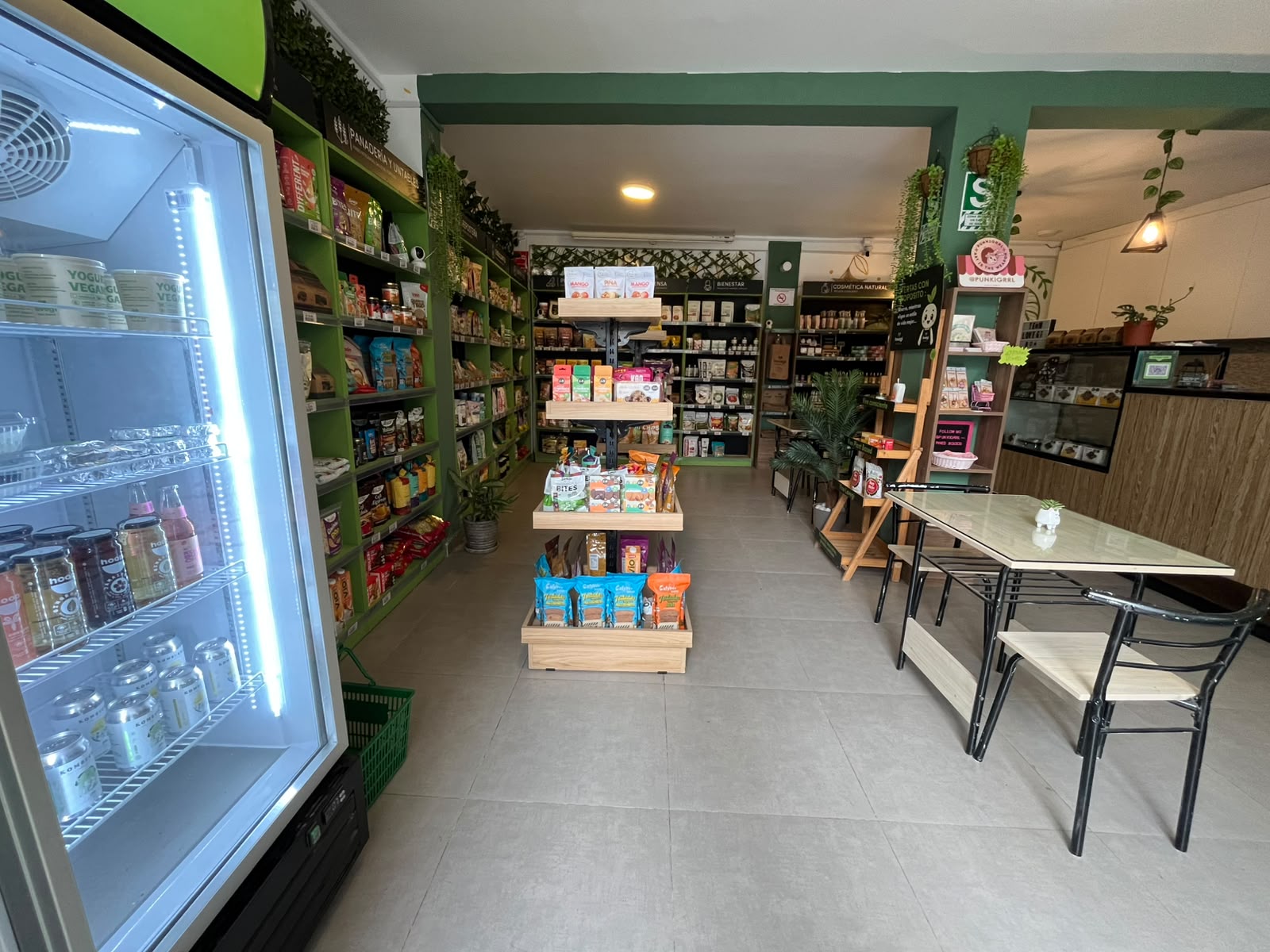 Sala de la tienda LOVEGI con exhibidores de productos plant based y mesas para clientes